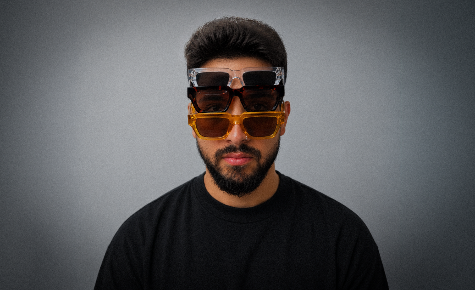 Karim wearing three stacked pairs of sunglasses